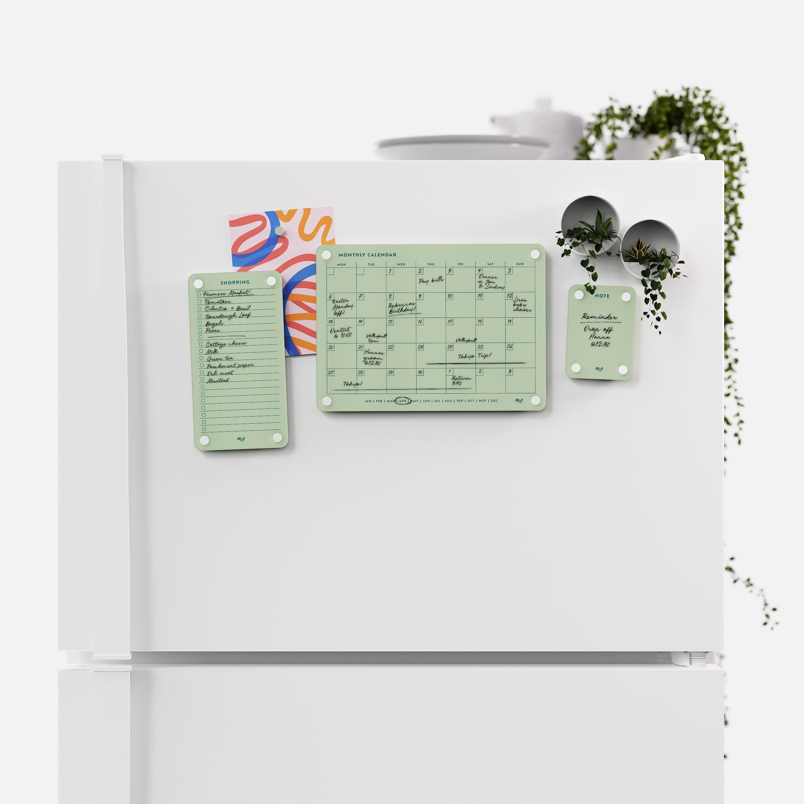 Matcha green shopping list, monthly calendar and note board arranged across a white fridge door